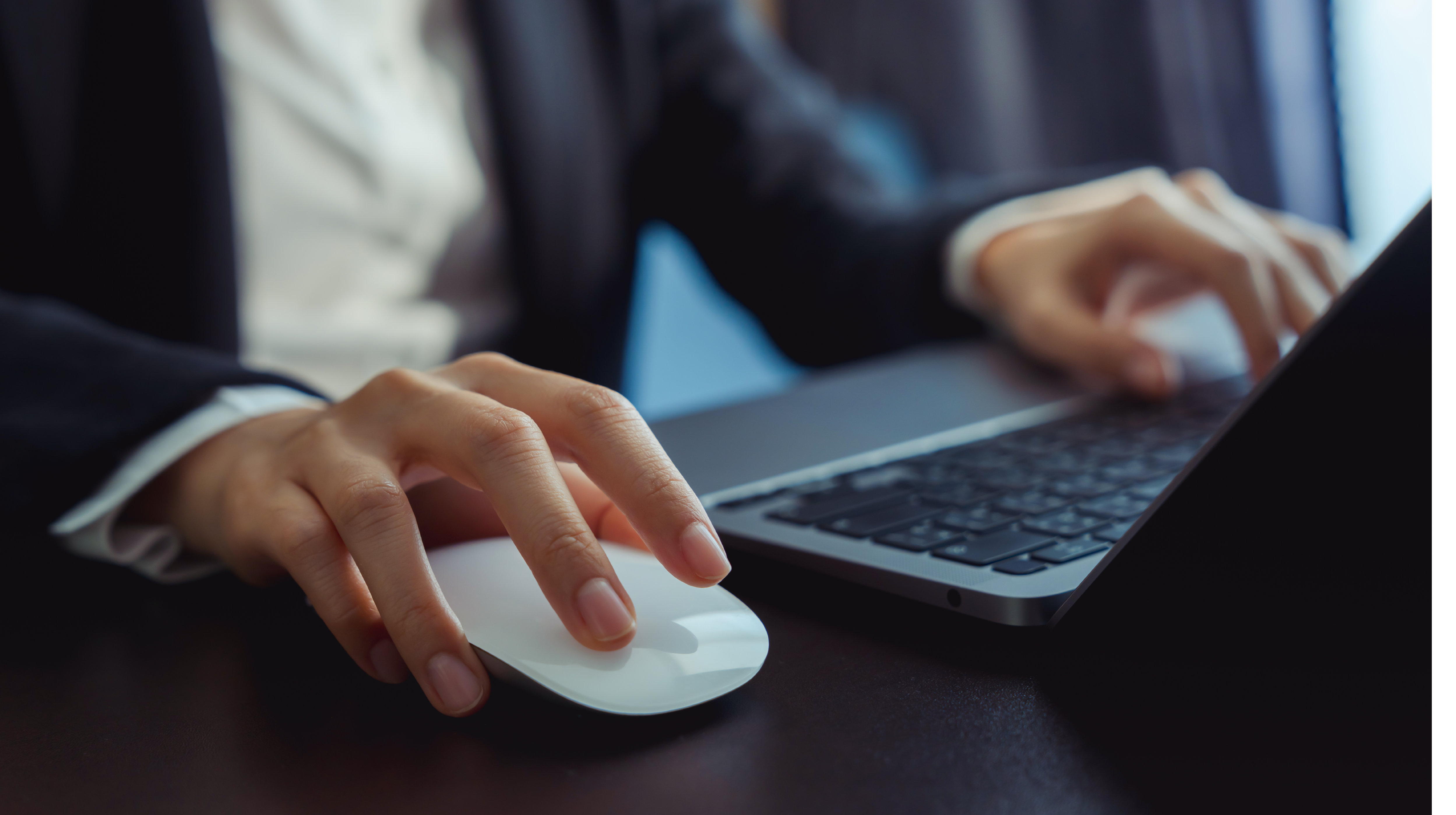 A person wearing a suit and tie is using a laptop computer. AI generated content