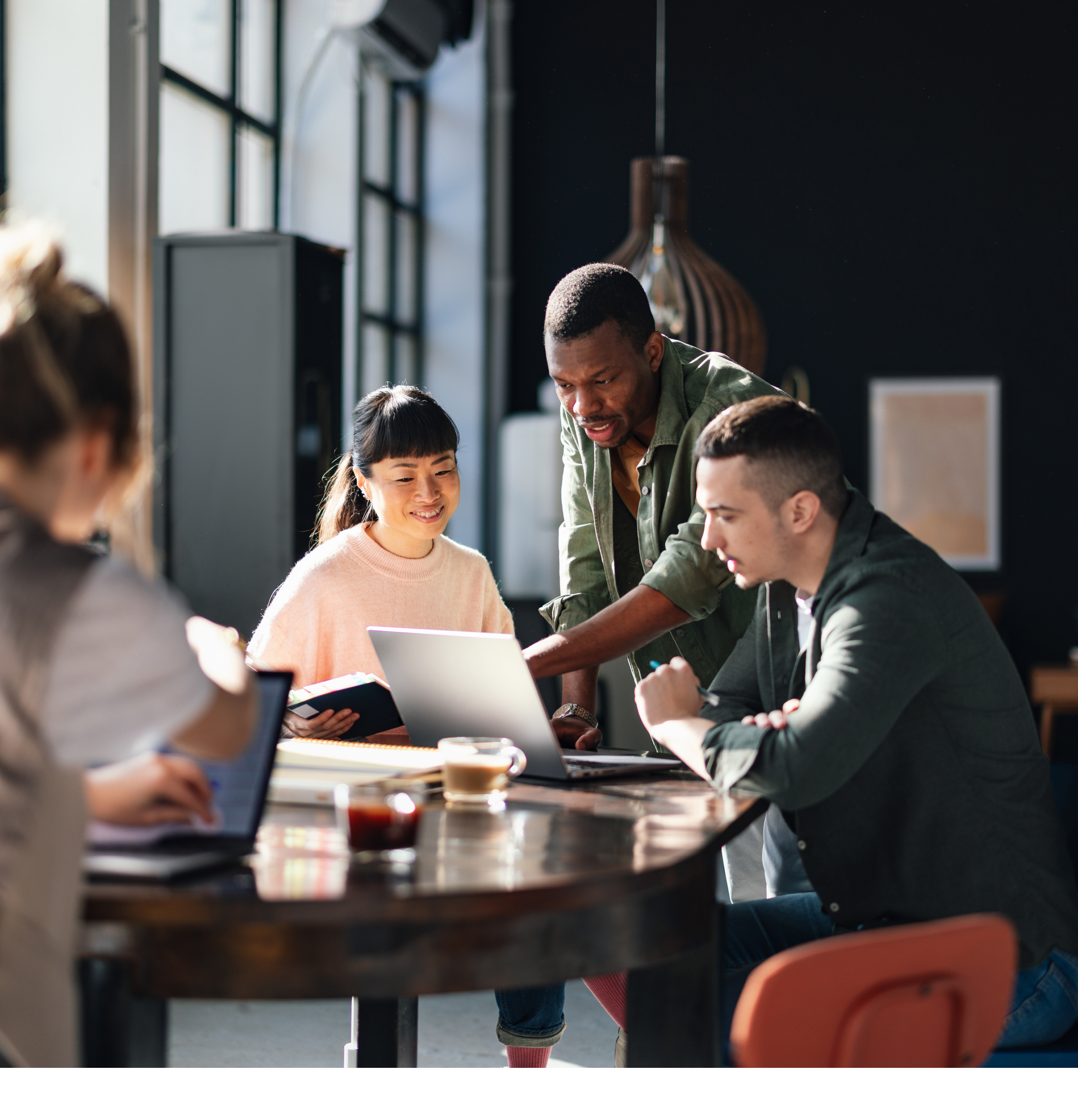 Young professionals or students collaborating in a bright, contemporary co-working environment, displaying teamwork and productivity.
