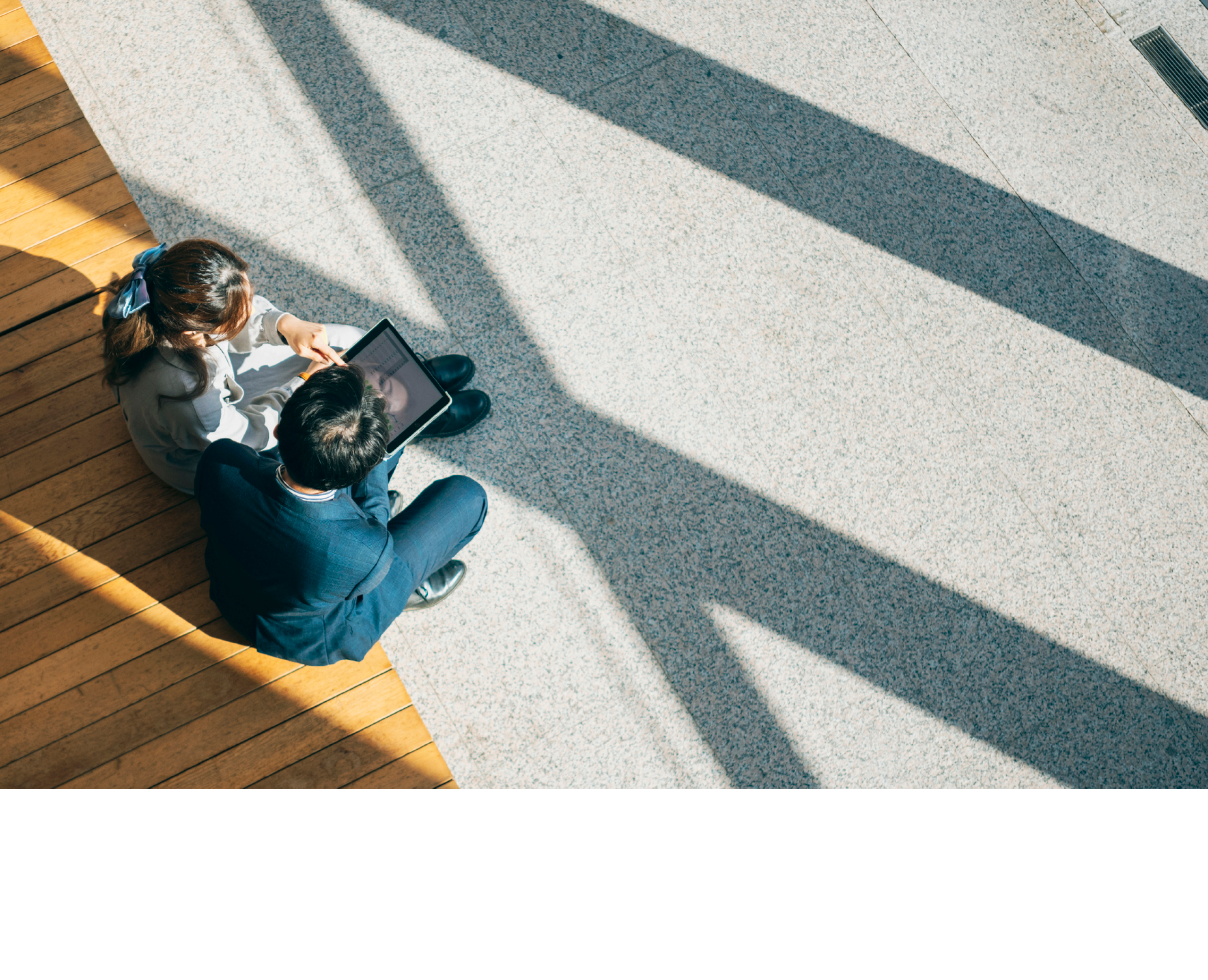Two businesspersons are seated on chairs in the lobby, seen from a high angle view, engaged in a focused discussion regarding business matters. The lobby might be a spacious and comfortable area, and they could be discussing business strategies, plans, or other work-related topics. Their expressions might convey professionalism and concentration, depicting a scenario of communication and discussion within a business environment.