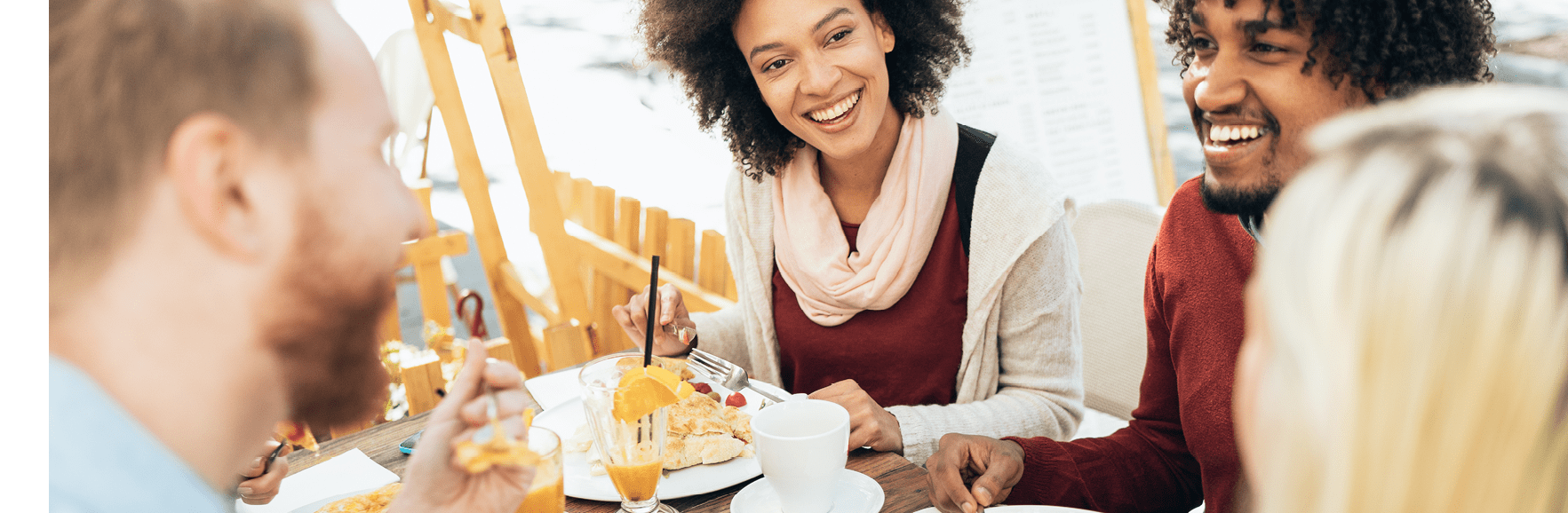 Multi-ethnic group of friends at restaurant outdoor having great time together