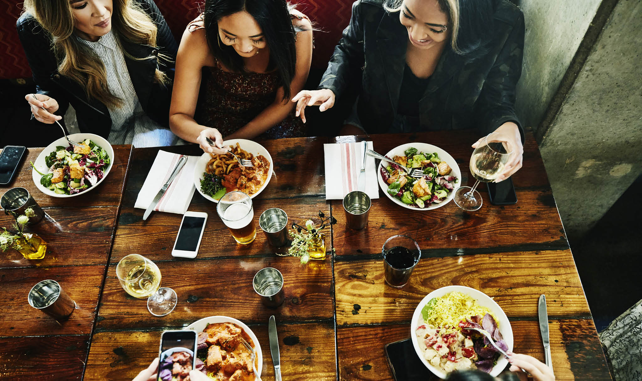 Overhead view of smiling female friends sharing lunch in restaurant