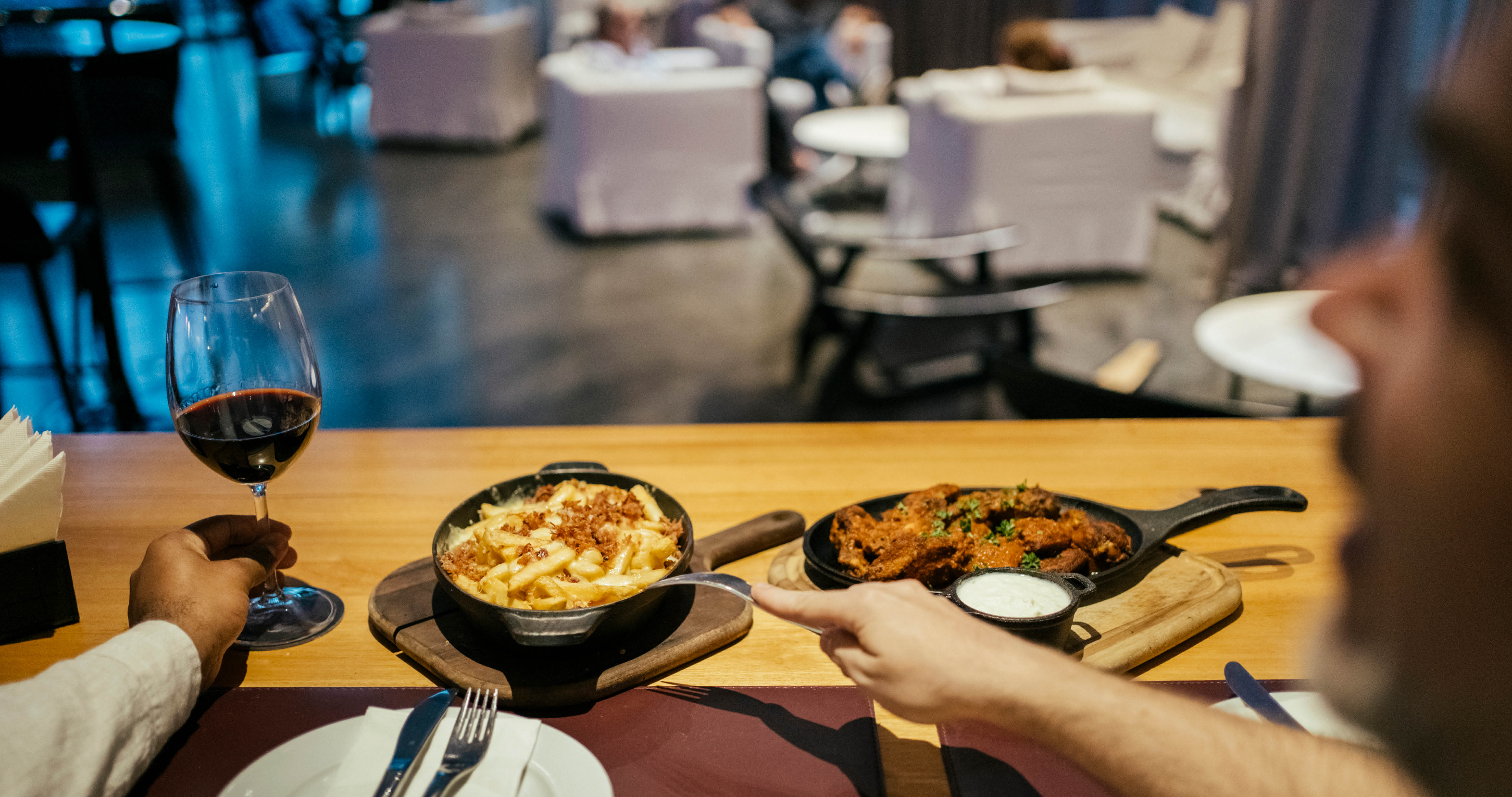 Gay couple eating and drinking at hotel bar