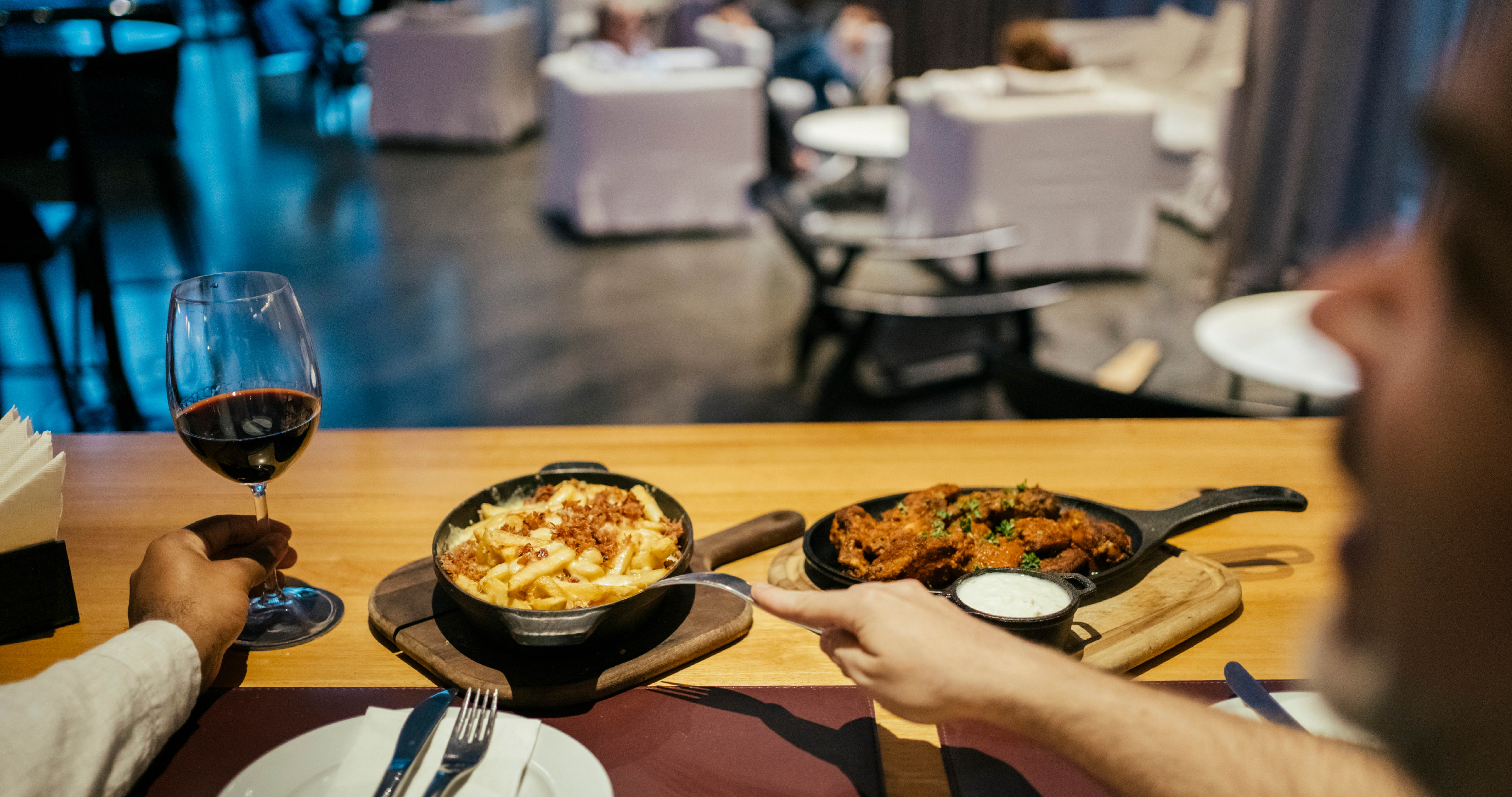 Gay couple eating and drinking at hotel bar