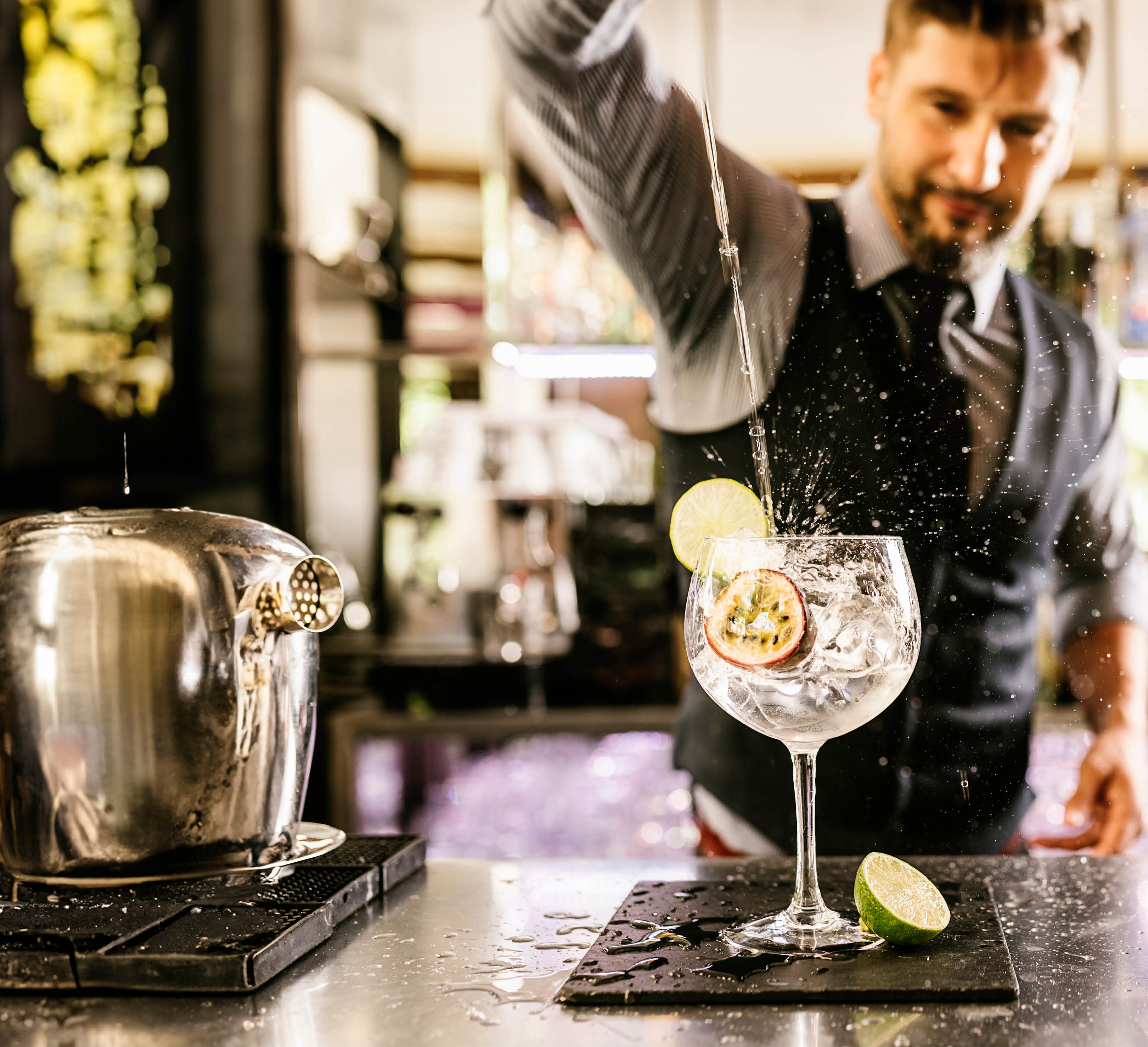 Expert barman is making cocktail at night club.