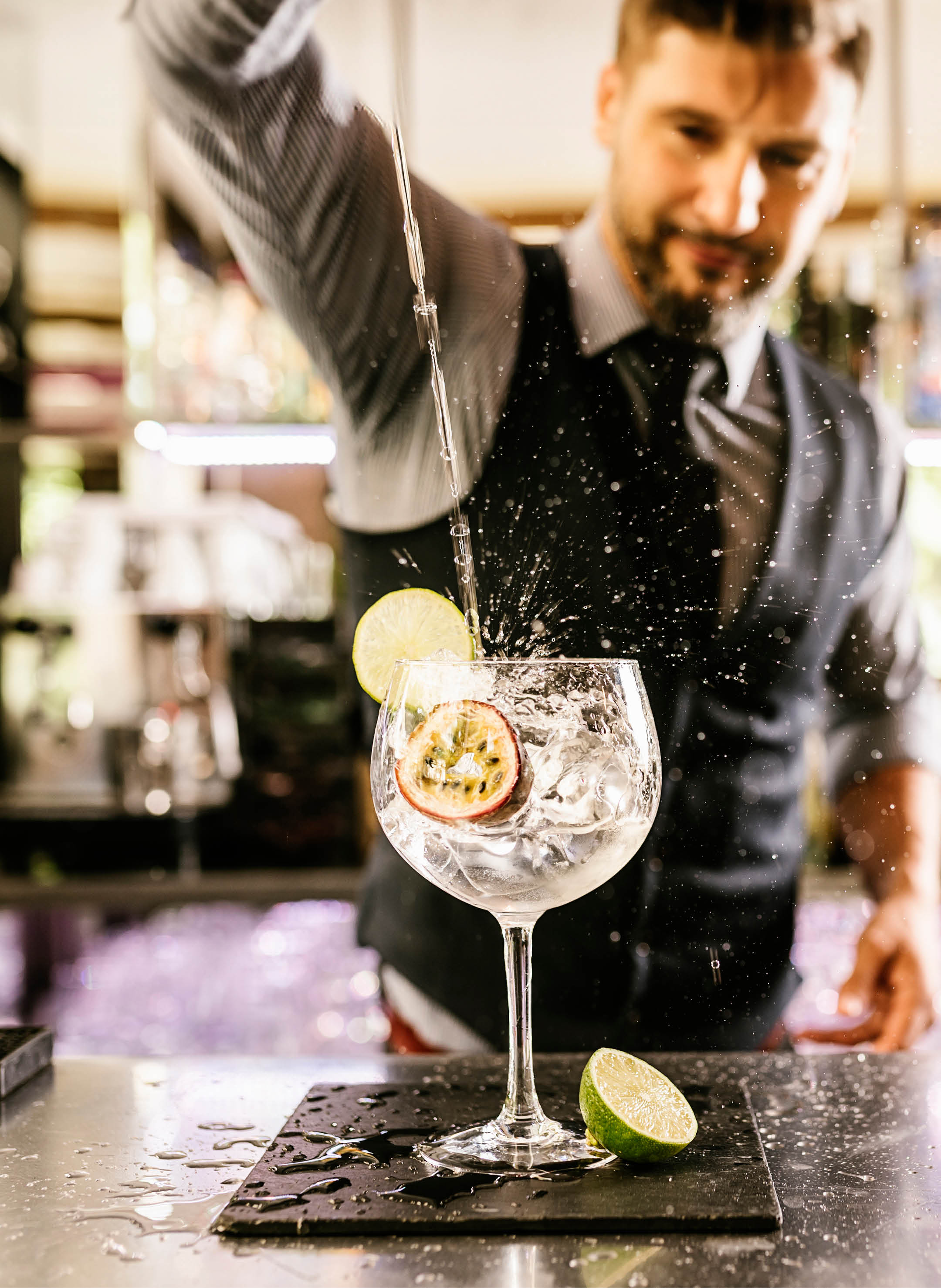 Expert barman is making cocktail at night club.