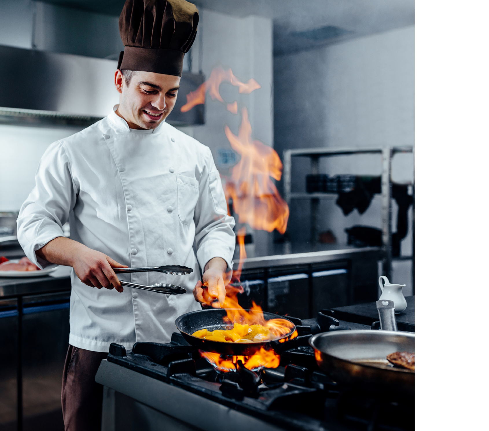 Cropped shot of a young male chef flambeing in a professional kitchen