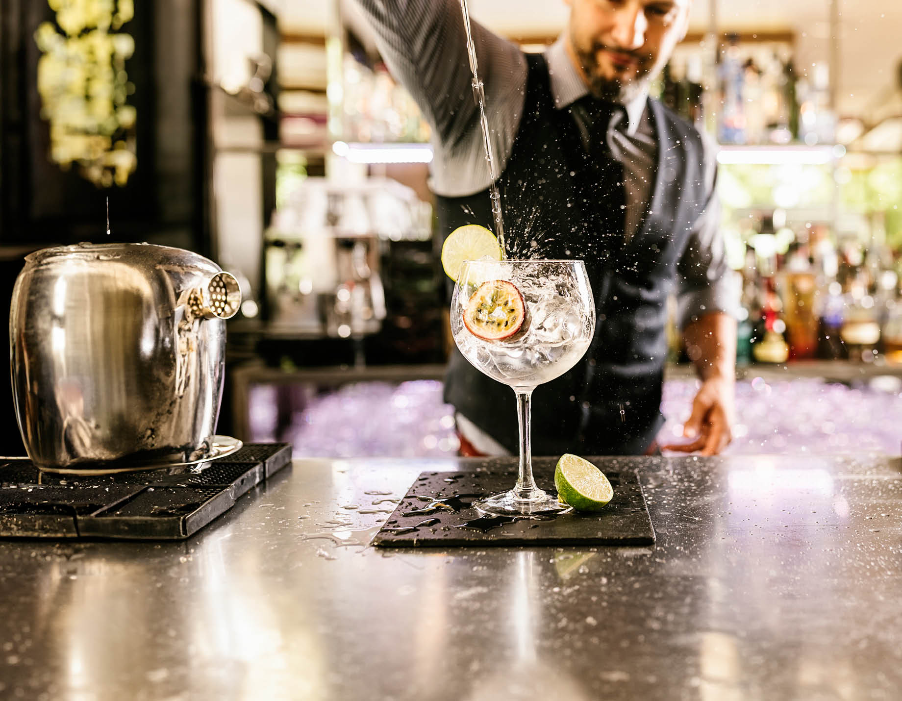 Expert barman is making cocktail at night club.