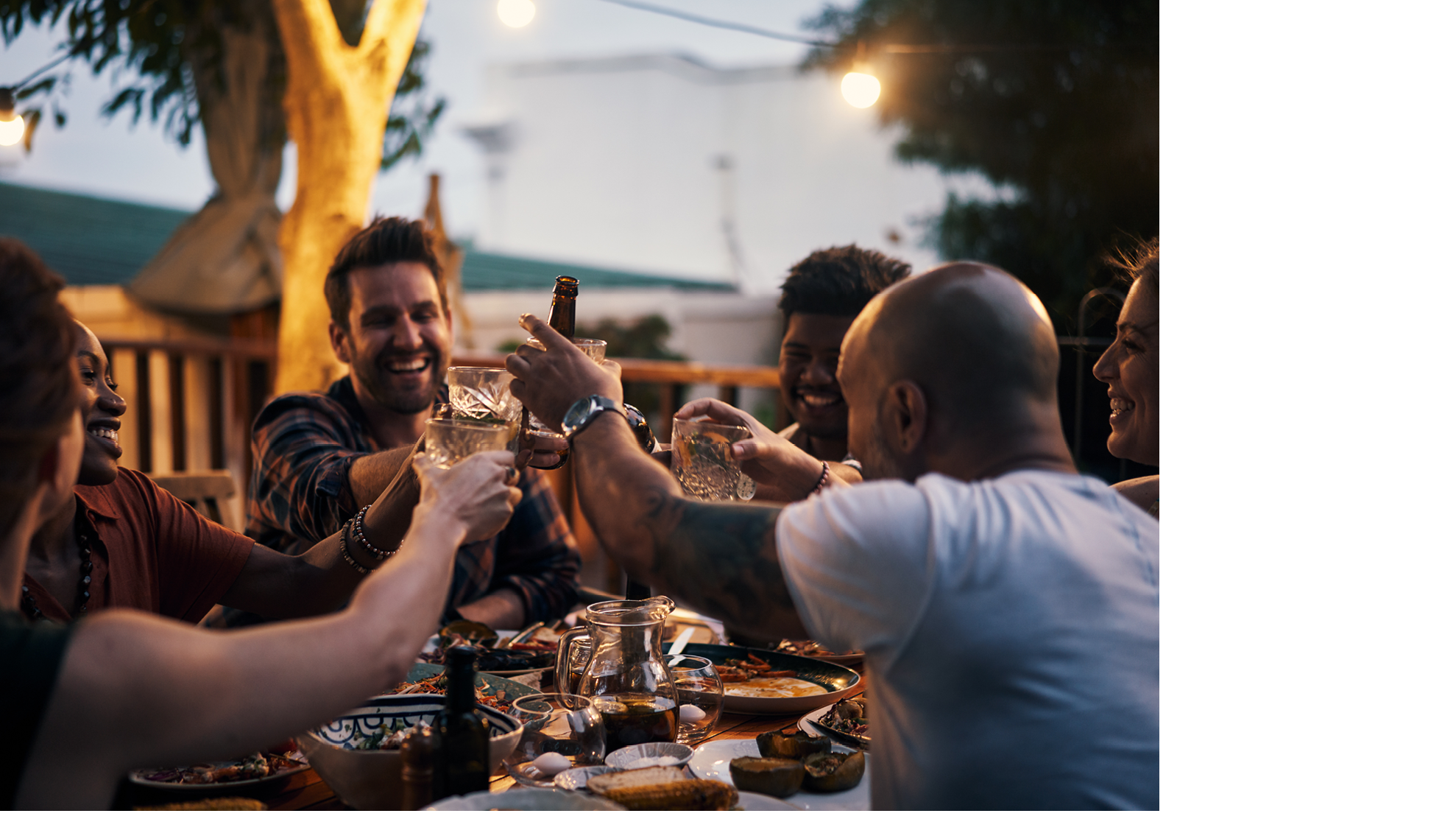 Shot of a group of young friends toasting with drinks at a dinner party outdoors
