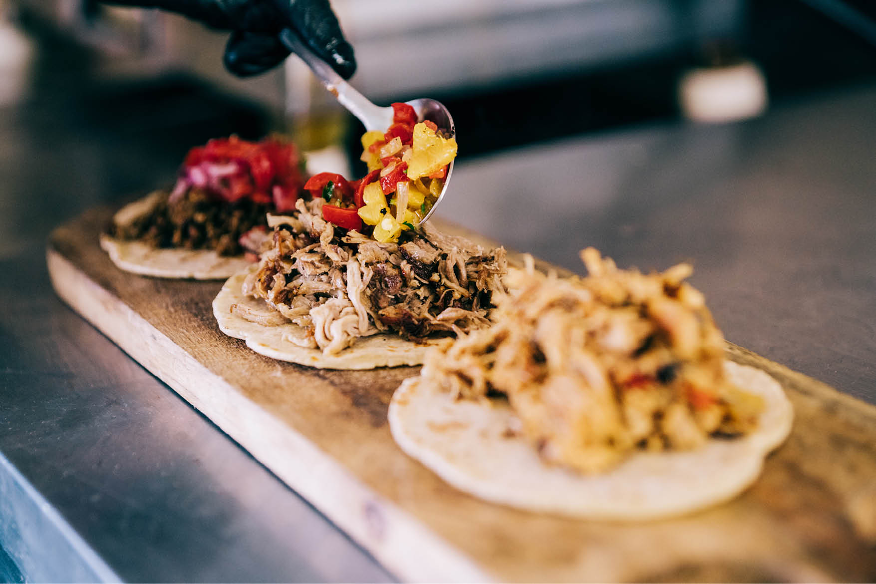 Shot of young chef preparing tacos in a food truck.