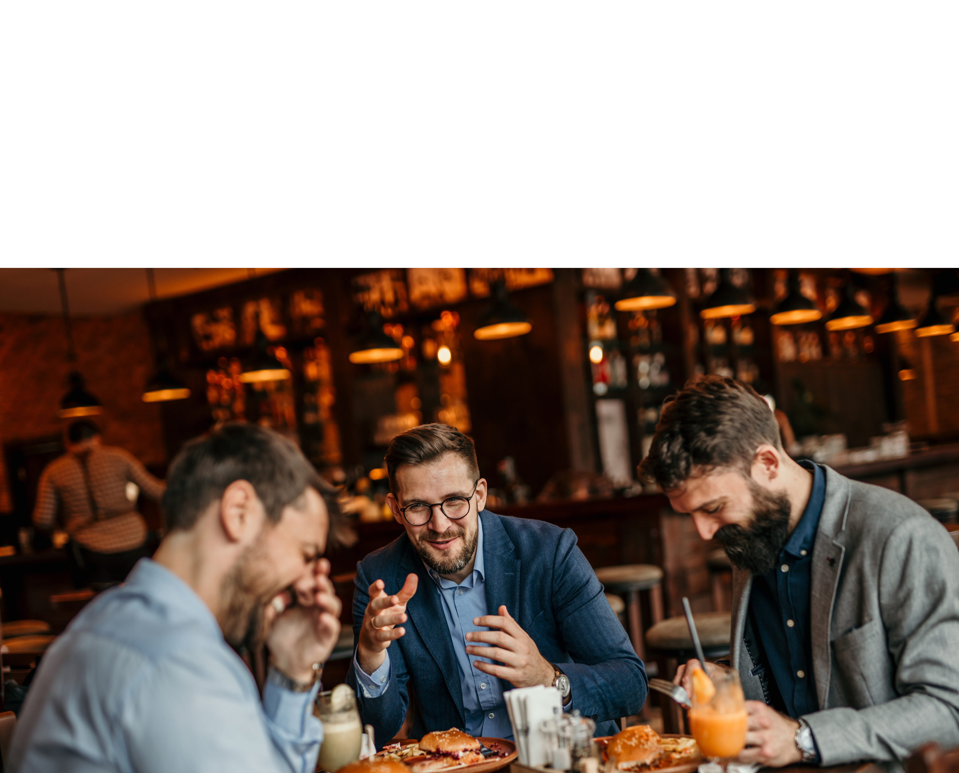 Group of businessmen enjoying a burger lunch while discussing work matters
