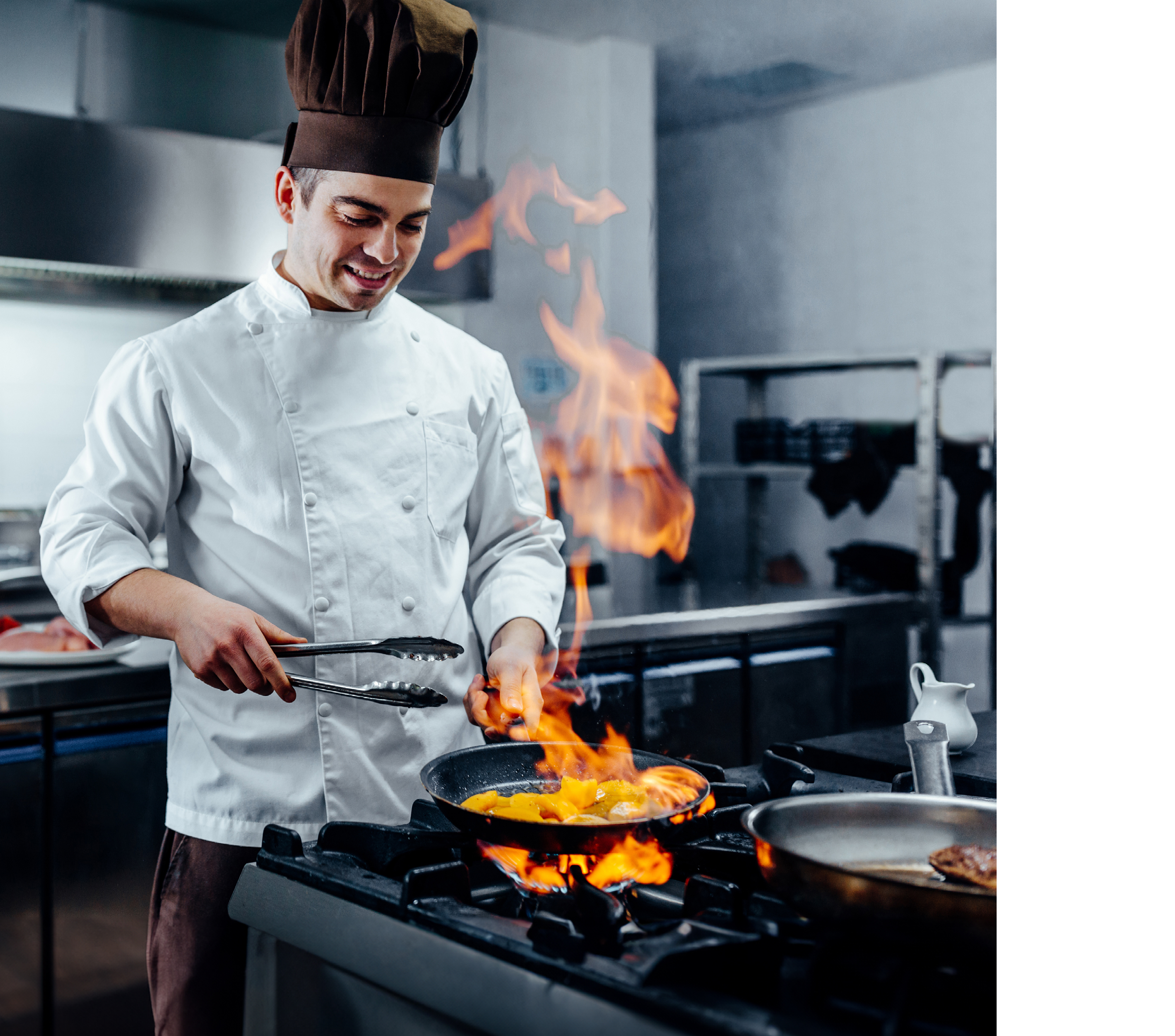 Cropped shot of a young male chef flambeing in a professional kitchen