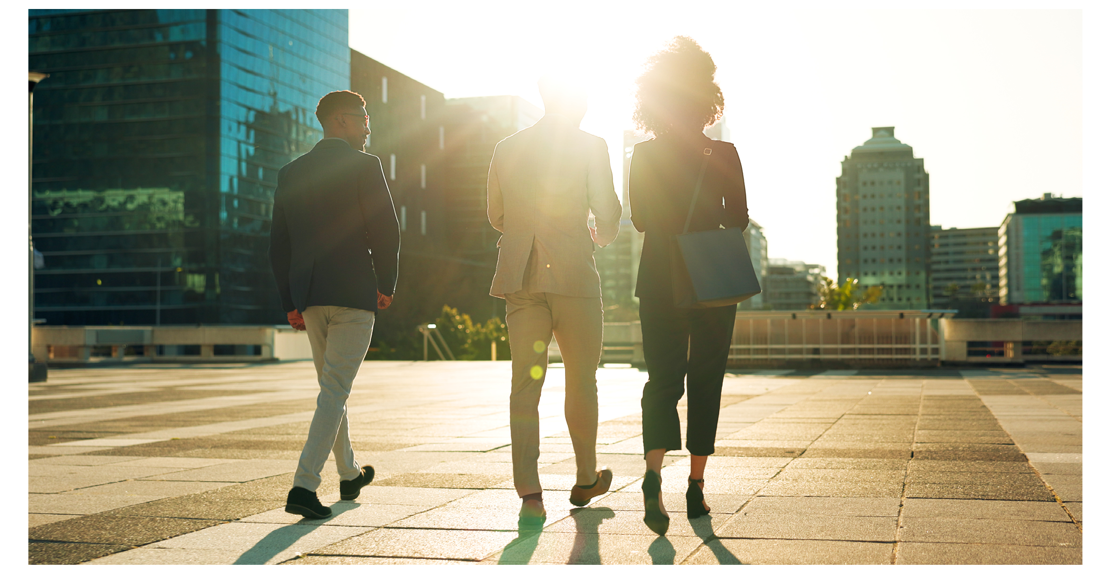 Back, business team and walking outdoor in city for morning travel to work, conversation and lens flare. Rear View, professional workers and moving in urban town with communication and networking