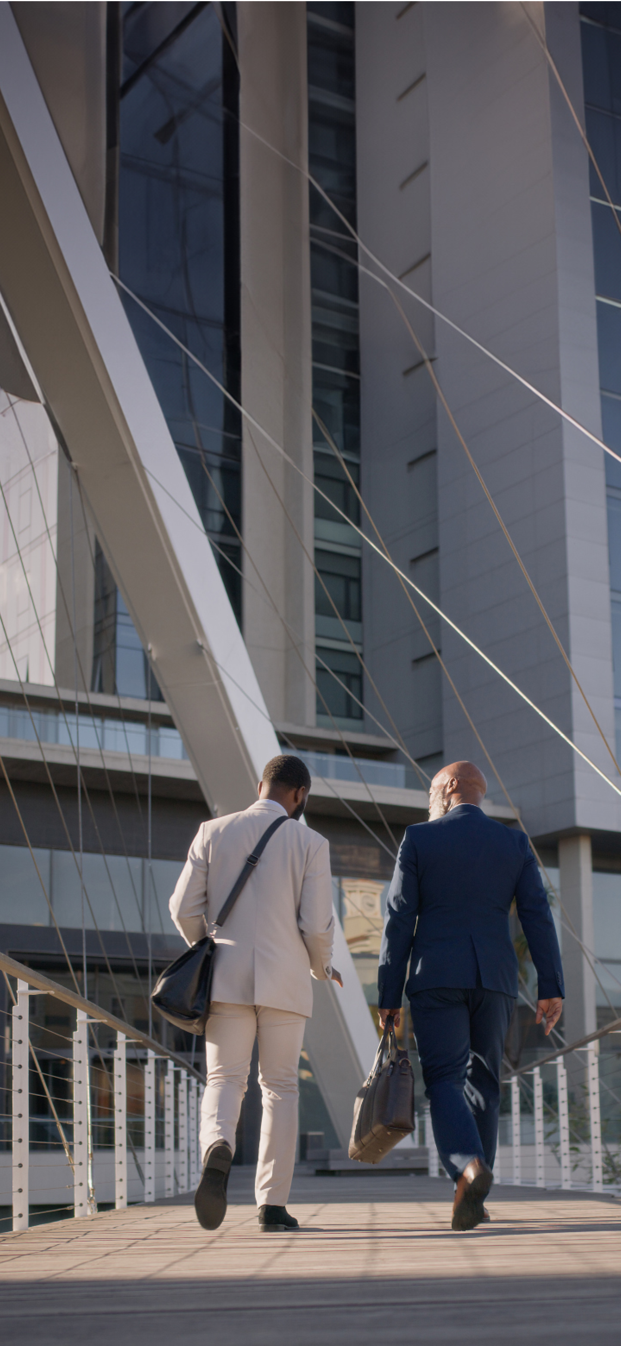 Walking, outdoor and business people on path to office building for work, commute and travel journey. Professional, men and back of staff with steps in progress on road in city or street in morning