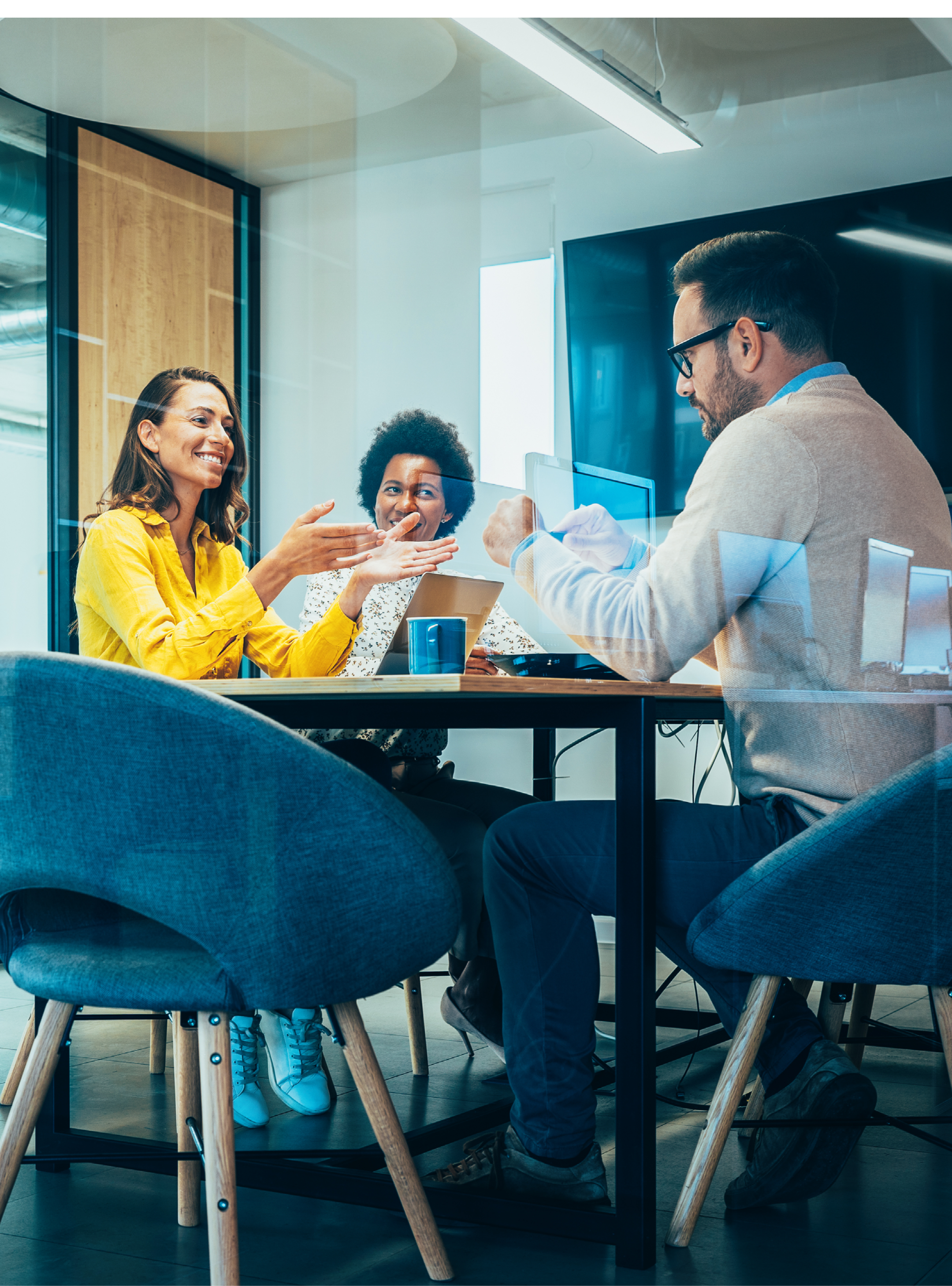 Businesspeople in Conference Room and Colleagues Walking By. Blurred motion of colleagues walking briskly down office hallway as colleagues sit in conference room discussing ideas. Busy modern workplace. Working process in the office, business people working, walking and talking, blurred motion