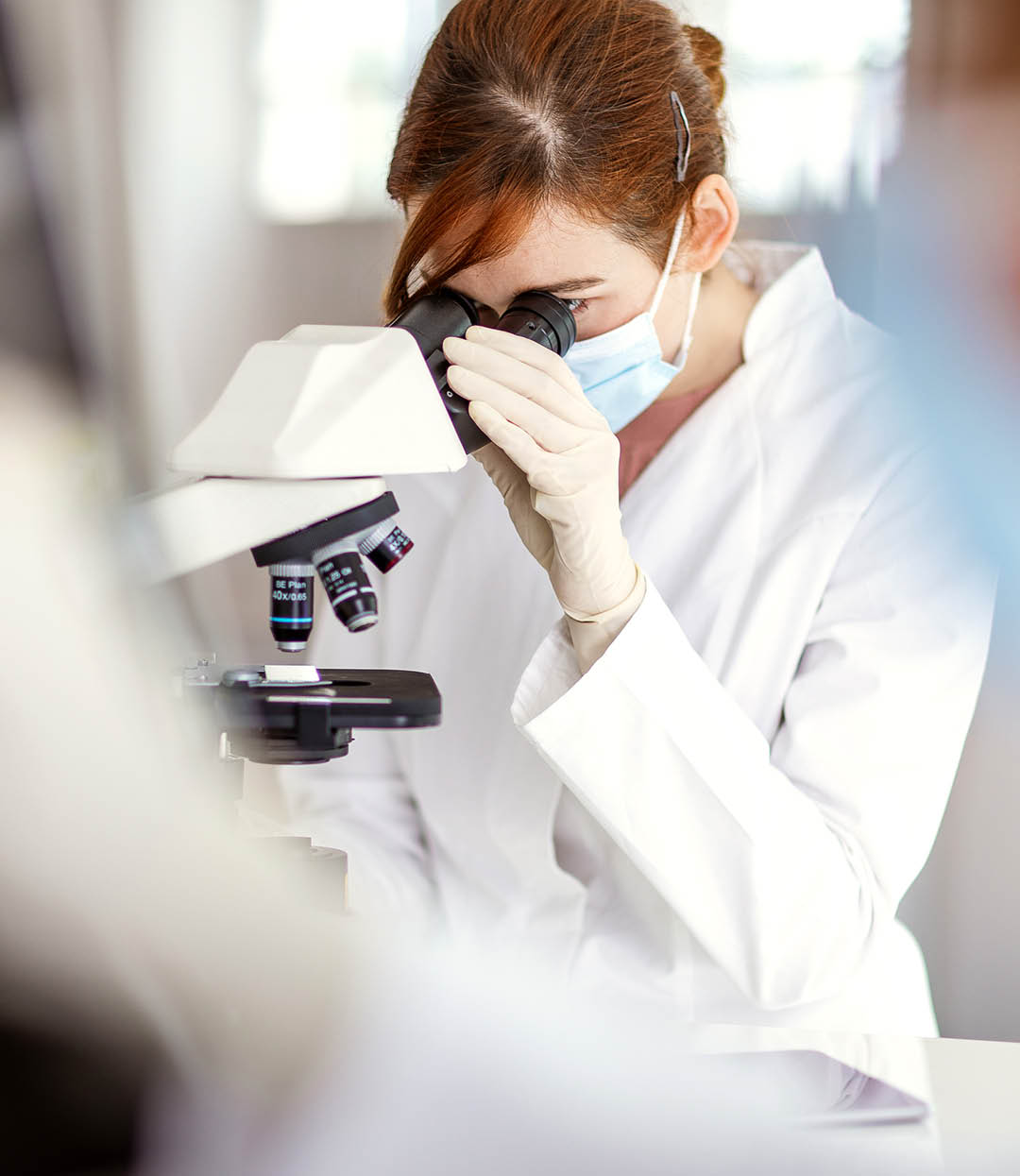 Scientist looking through a microscope