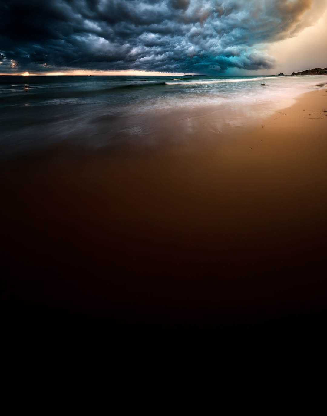 Powerful dramatic storm cell over ocean beach with golden light, Australia