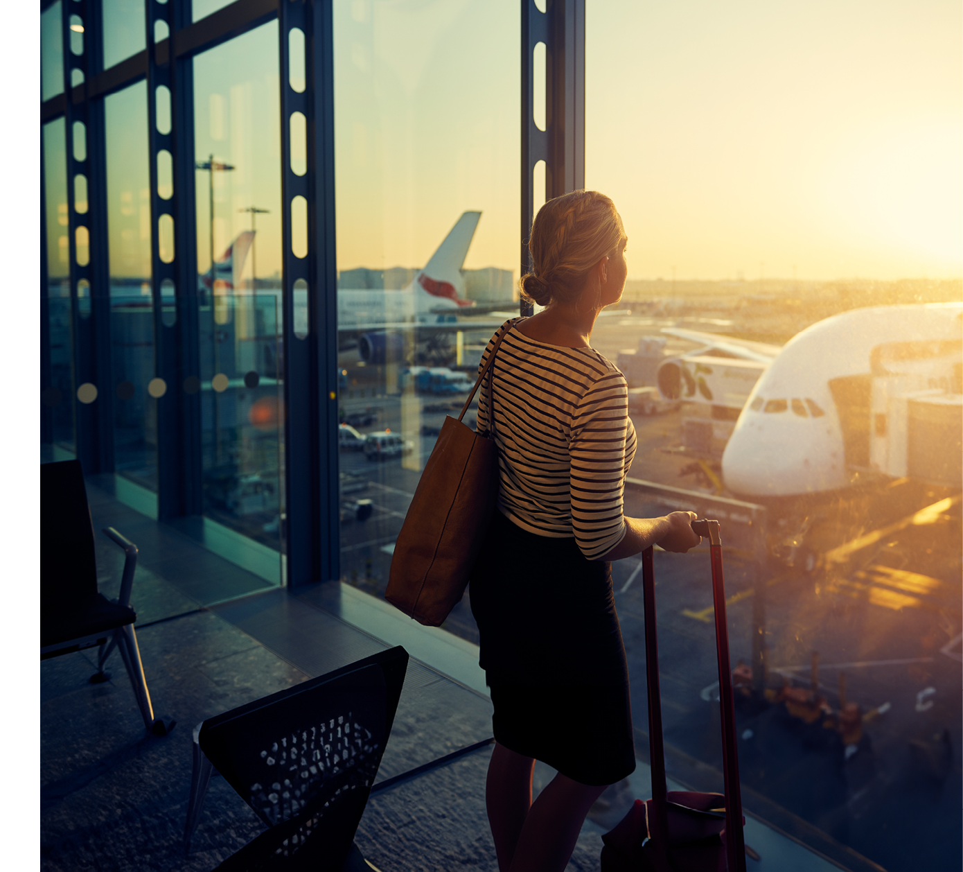 Shot of a young woman looking through the window of an airport departure lounge