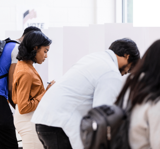 The young adult female businesswoman reads her ballot carefully before making her selections.