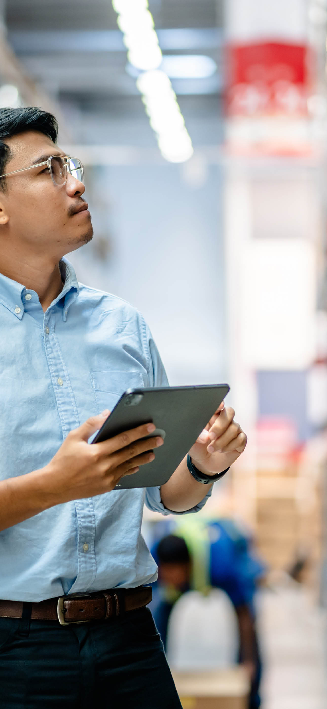 Businessmen or manager use a digital tablet to check the stock inventory on shelves in large warehouses, a Smart warehouse management system, supply chain and logistic network technology concept.