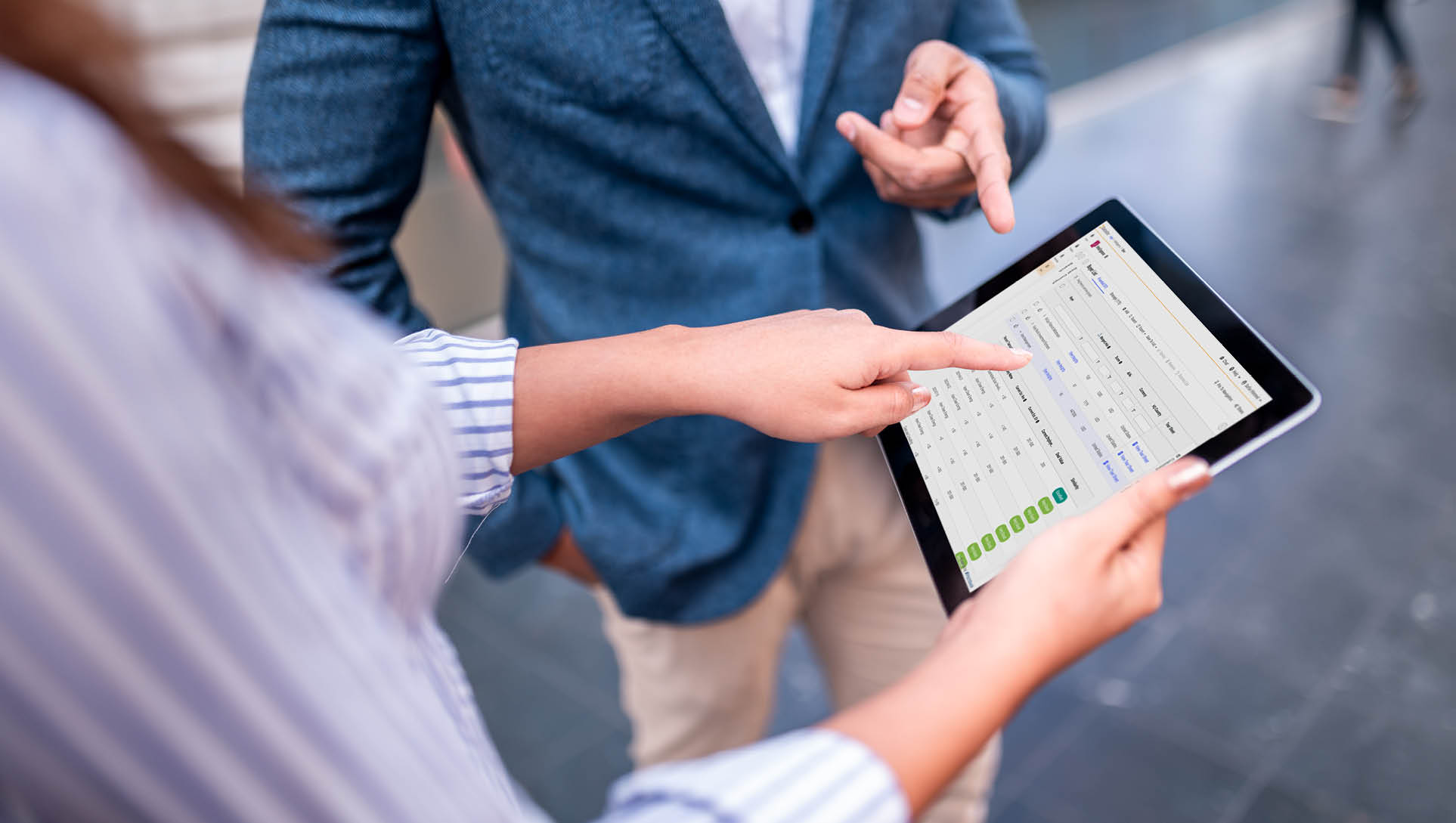 Shot of a digital tablet being held by a businesswoman, while businessman is showing something with his finger on the screen