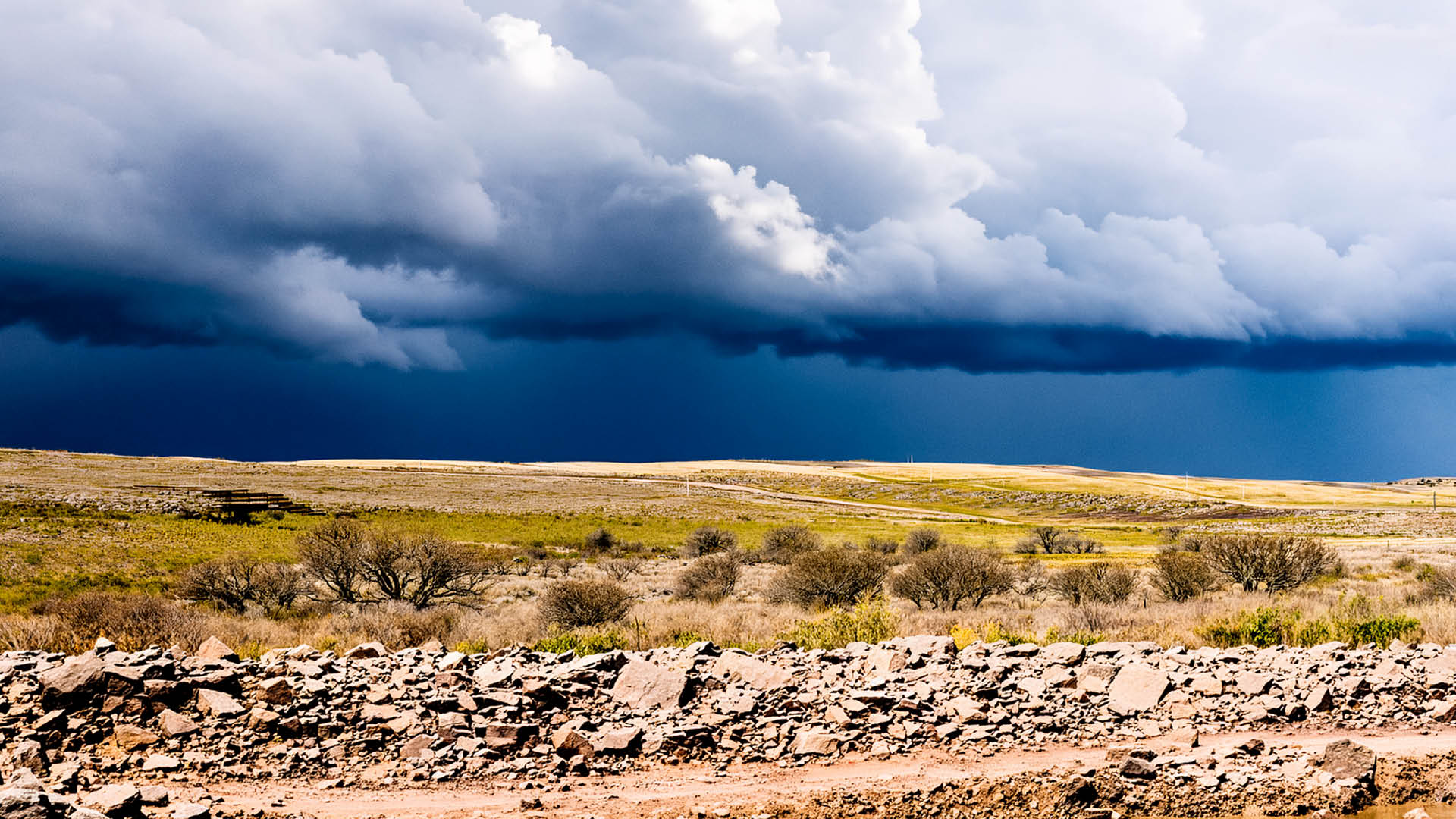 A horizon of rural land in Utah, USA, with the asphalt surface of the highway in the foreground.