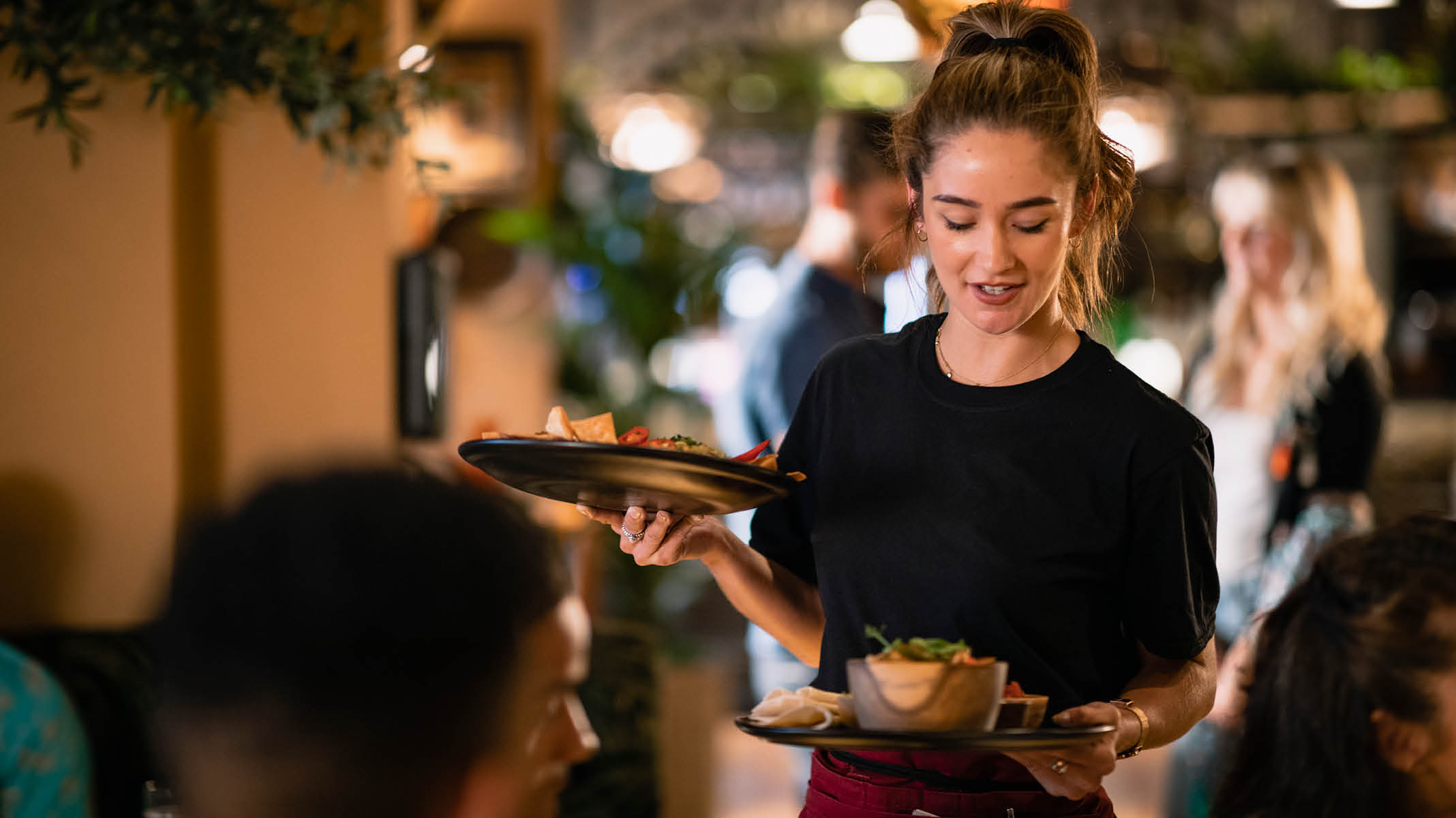 A waitress serving customers food at a restaurant in Newcastle-Upon-Tyne.