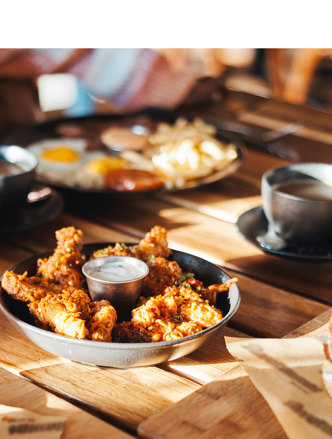 Fast food, lunch or dinner on table at restaurant, people eating for nutrition and wellness with time together. Catering, hospitality and cuisine with burger, chicken and ribs for protein at diner