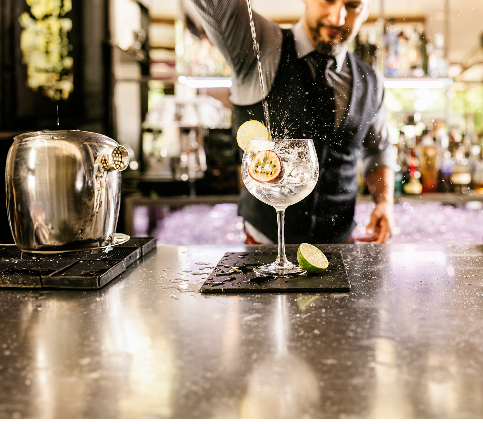 Expert barman is making cocktail at night club.