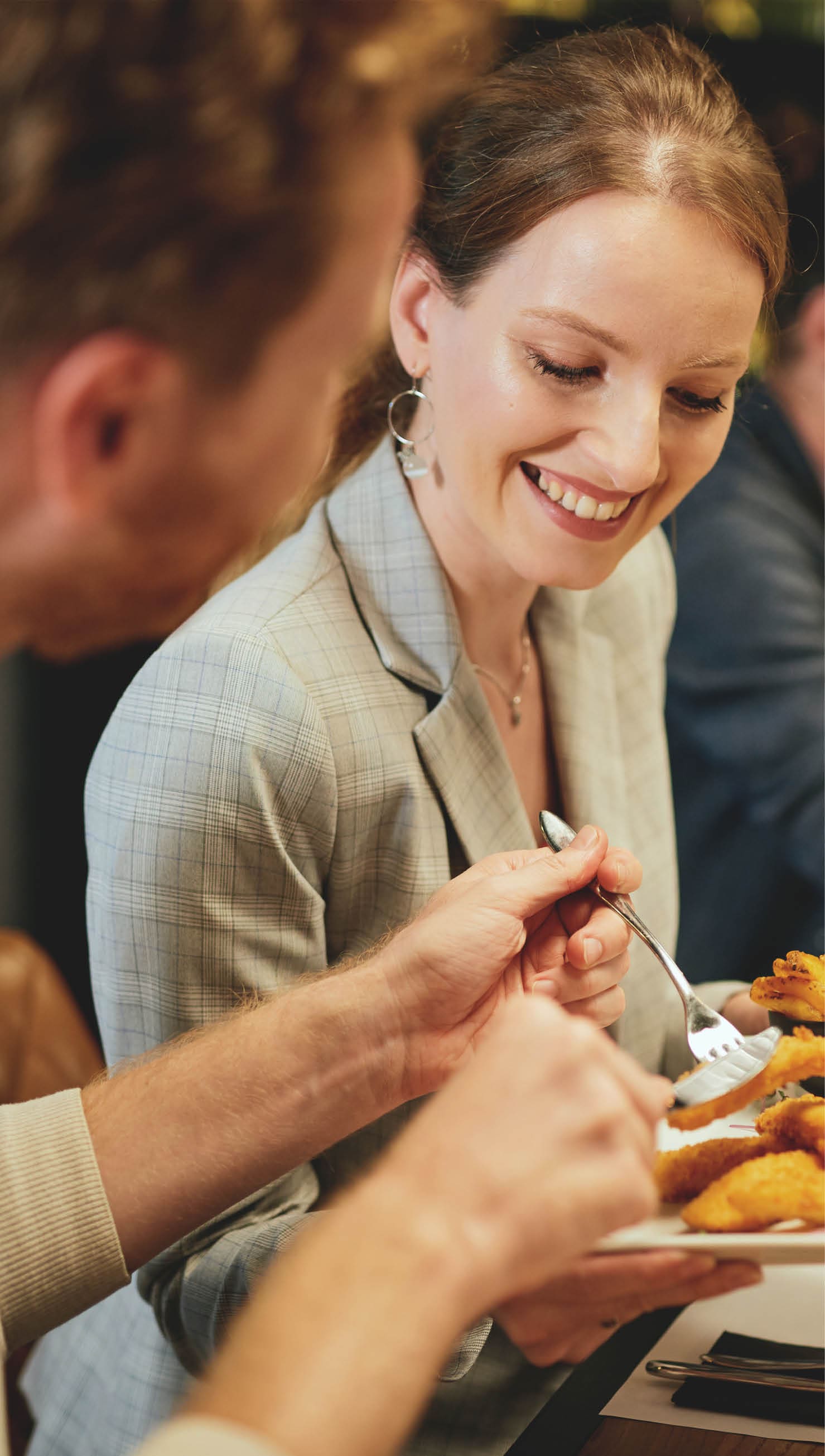Young couple sitting in restaurant and sharing food 