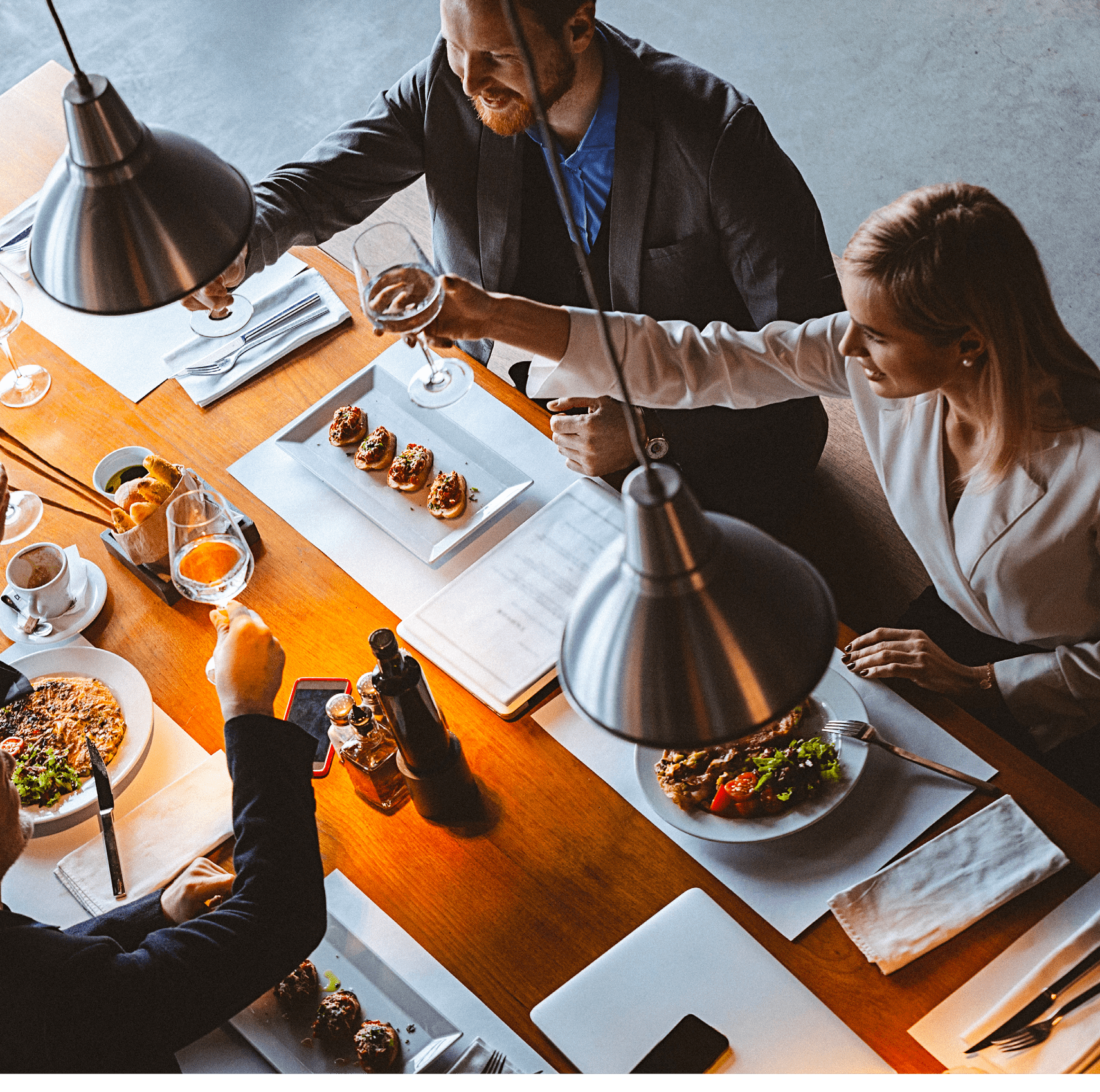 High angle view photo of a group of friends toasting during lunch time in a high-end reastaurant  It could be that they are business people having a business lunch  All are well dressed  The shot is executed with available natural light and the copy space has been left 